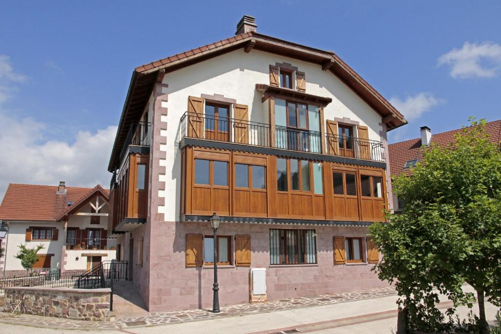 un gran edificio con un balcón en la parte superior. en Apartamentos Irati Garralda, en Garralda