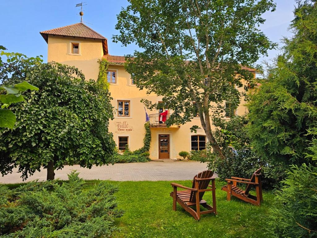 un grande edificio giallo con due panchine davanti di Bille a Bille