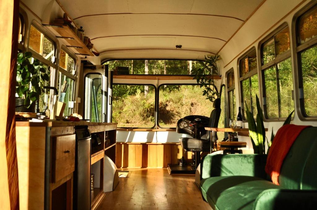 salon z zieloną kanapą w autobusie w obiekcie Coffee Grounds - The Bus w mieście Coffee Camp
