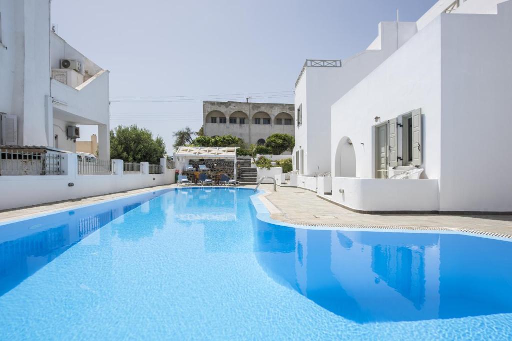 a swimming pool with blue water in a building at Nissos Thira in Fira