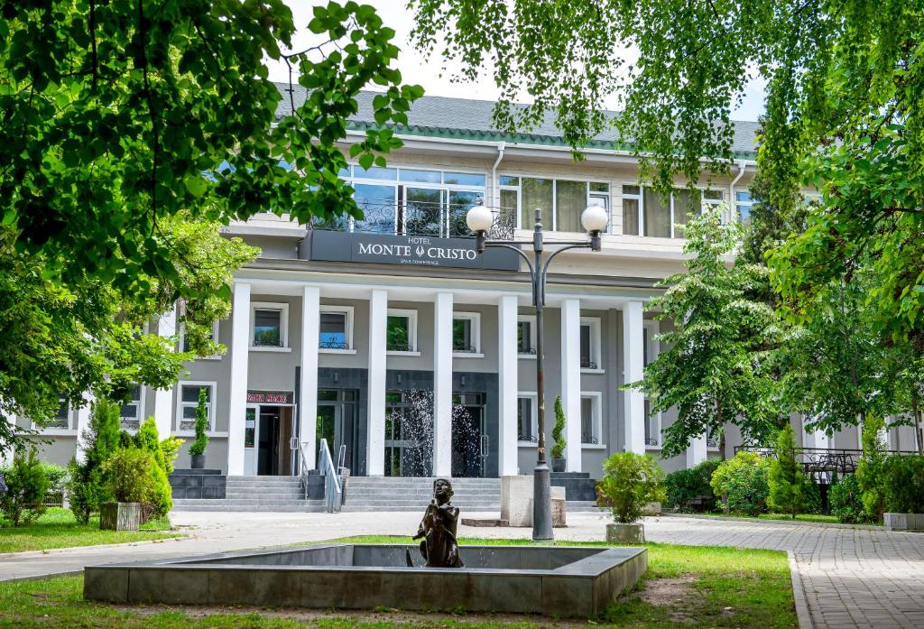 a building with a statue in front of it at Hotel Monte Cristo in Blagoevgrad