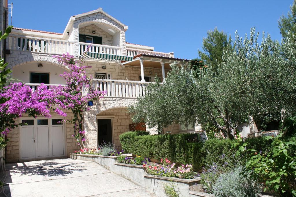 Una casa grande con un jardín enfrente. en Apartments Jagoda, en Bol