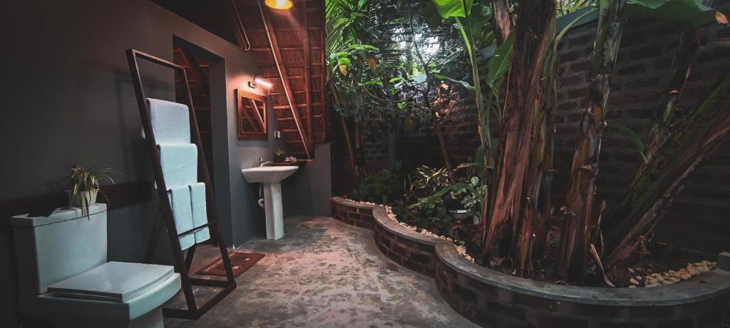 a bathroom with a sink and a large plant at NJ House in Tangalle