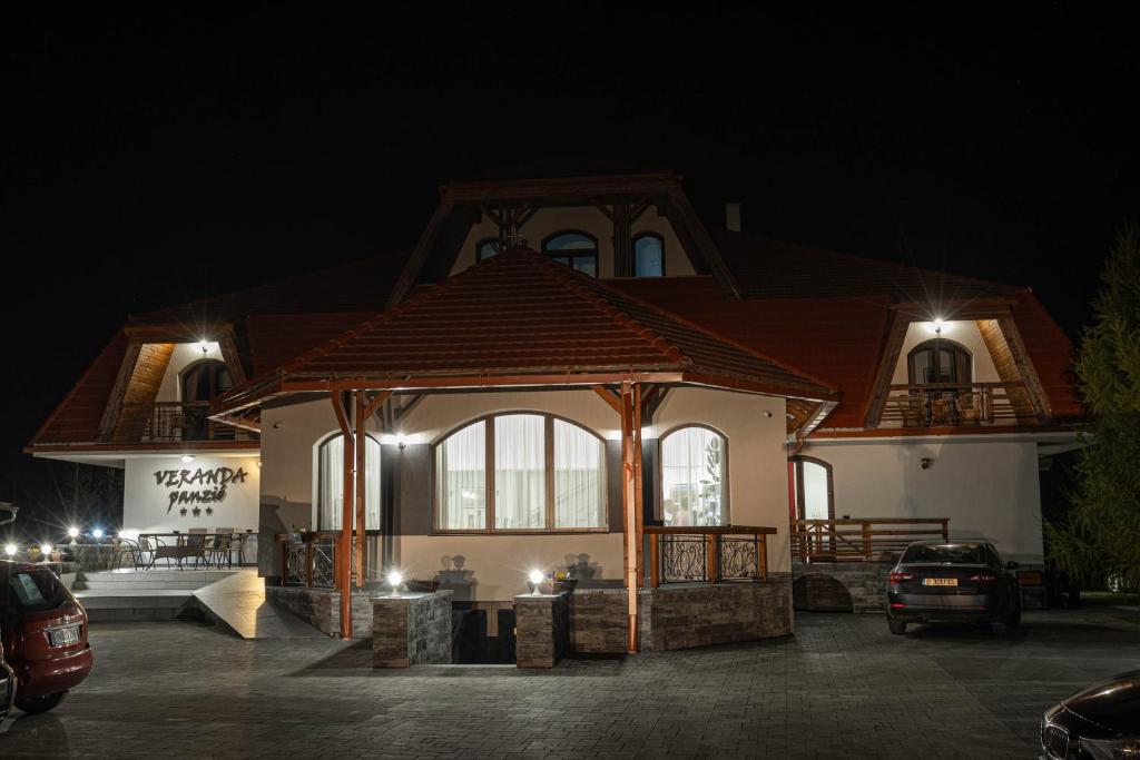 a house with a gazebo in a parking lot at night at Veranda Panzio in Remetea