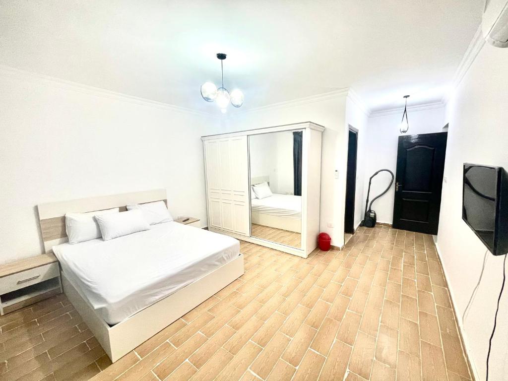 um quarto com uma cama branca e um espelho em Maison de repos em New cairo