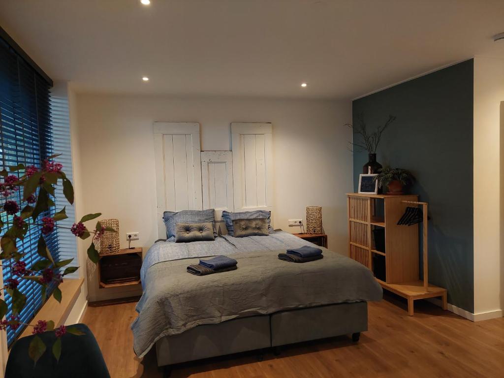 1 dormitorio con 1 cama grande con almohadas azules en Smaakvol Slochteren, en Slochteren