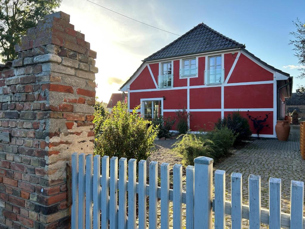 WartheにあるVictor`s Farmhaus - Refugium für 2,6 oder 8 Personenの白い柵の赤い家