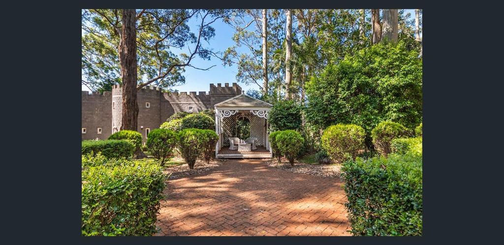 a garden with a gazebo in front of a house at The Gamekeepers Spa Cottage in Tamborine Mountain in Mount Tamborine