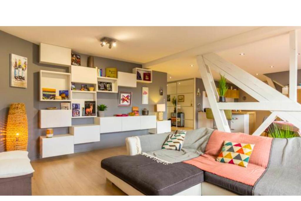 a living room with a couch and a staircase at Le Victor Hugo Appartement T3 proche Musée Soulages in Rodez