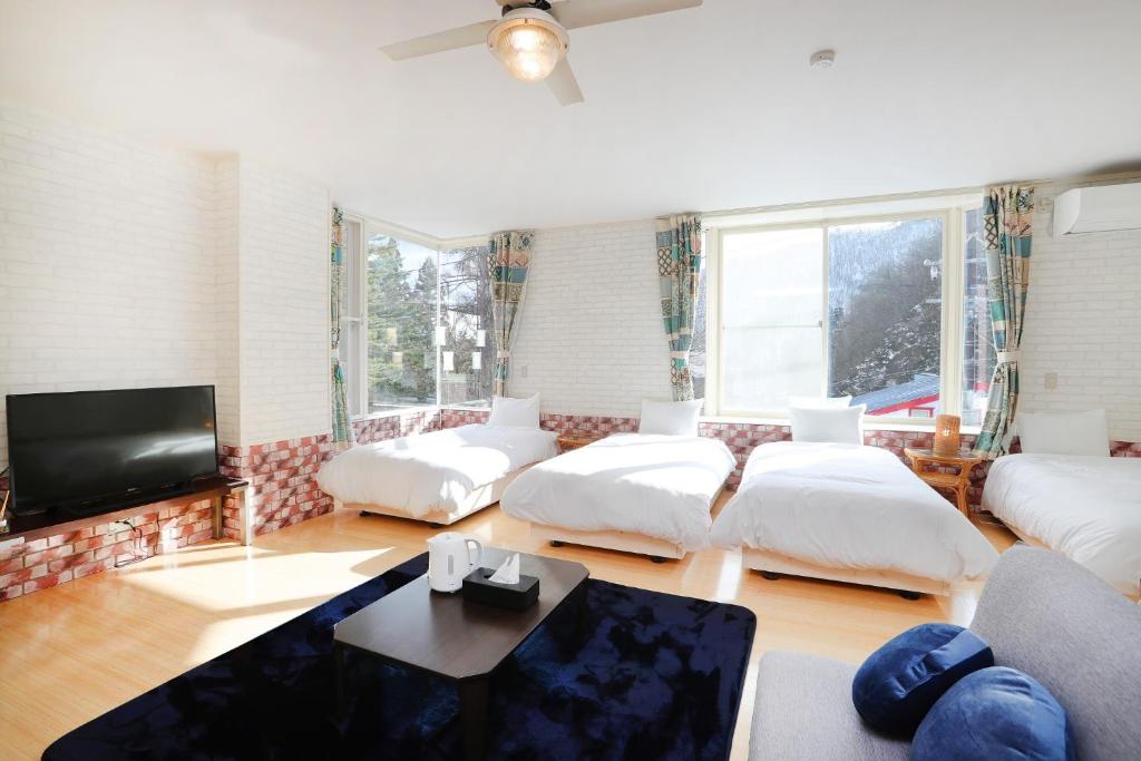 sala de estar con muebles blancos y TV de pantalla plana en LIFT IN HAKUBA GORYU - Vacation STAY 96382v en Iida