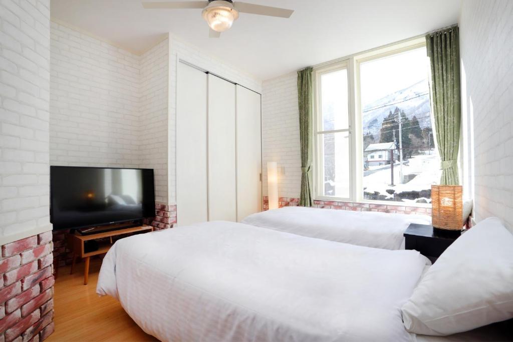 1 dormitorio con 2 camas y TV de pantalla plana en LIFT IN HAKUBA GORYU - Vacation STAY 71289v, en Iida
