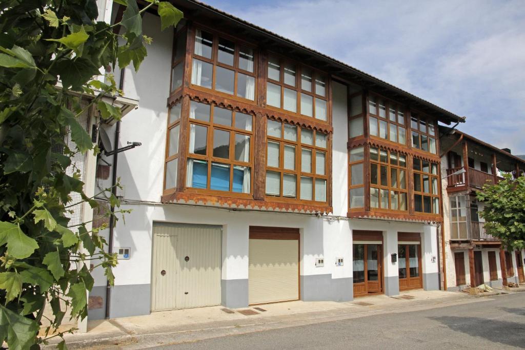 un edificio blanco con ventanas marrones y blancas en Apartamentos Irati Olaldea, en Oroz-Betelu