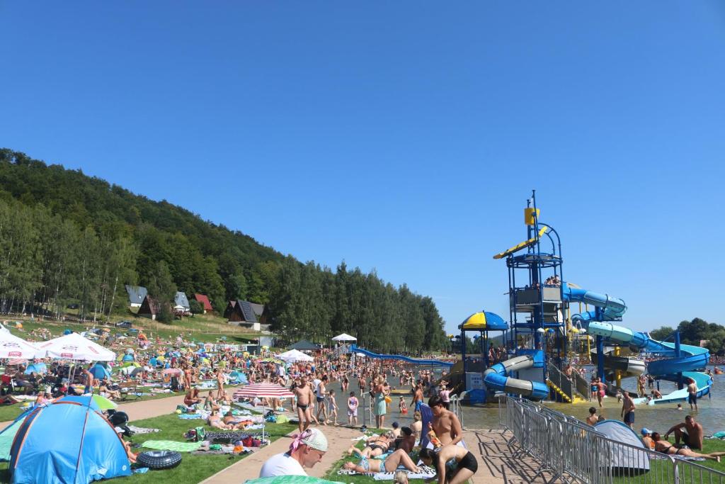 una multitud de personas en la playa en un parque acuático en APARTAMENTY Kolonia Leśna en Radków