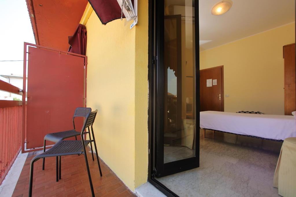two chairs and a mirror in a room with a bed at Hotel Primavera in Peschiera del Garda