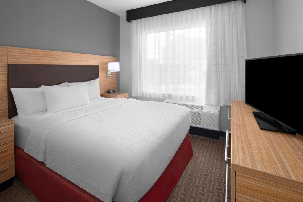 a hotel room with a bed and a flat screen tv at TownePlace Suites by Marriott Kingsville in Kingsville