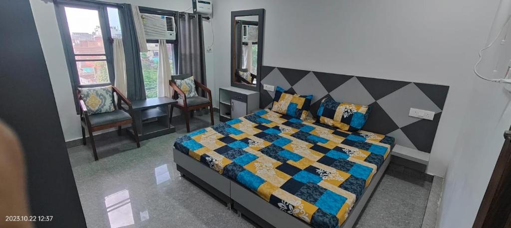 1 dormitorio con 1 cama con colcha colorida en Hotel Karan, en Kathua