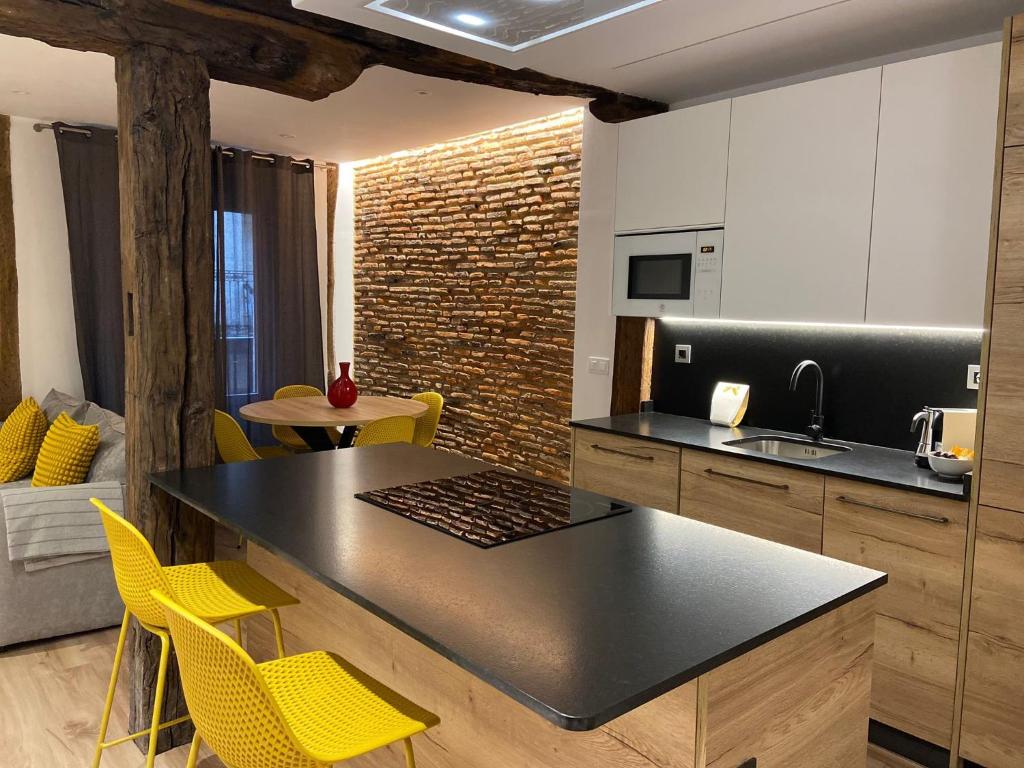 eine Küche mit einem Tisch und gelben Stühlen in einem Zimmer in der Unterkunft Apartamento Deluxe Casco Viejo in Bilbao