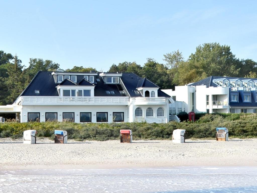 ein großes weißes Haus auf einem Strand in der Unterkunft Hotel Seeschlösschen in Hohwacht