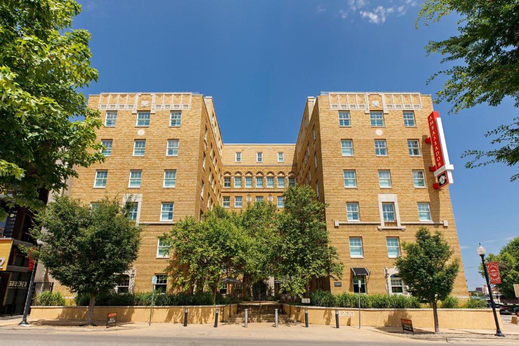 a large brick building with trees in front of it at Ambassador Hotel Oklahoma City, Autograph Collection in Oklahoma City
