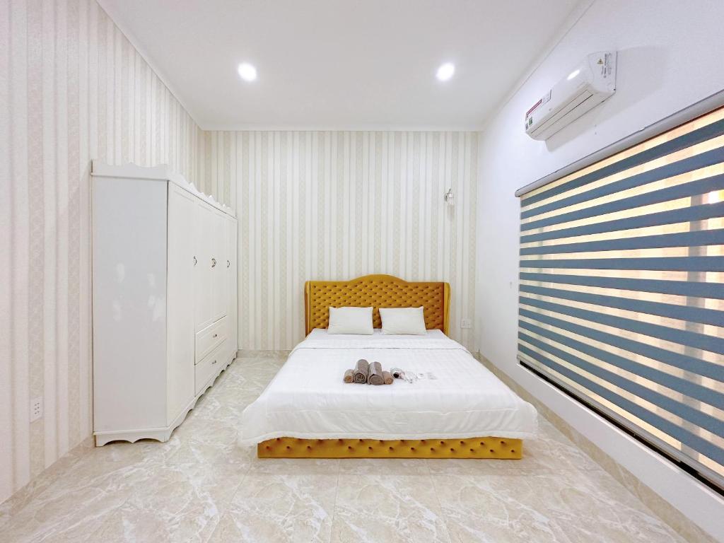 Un dormitorio con una cama con un osito de peluche. en Ahome en Buôn Ðũng