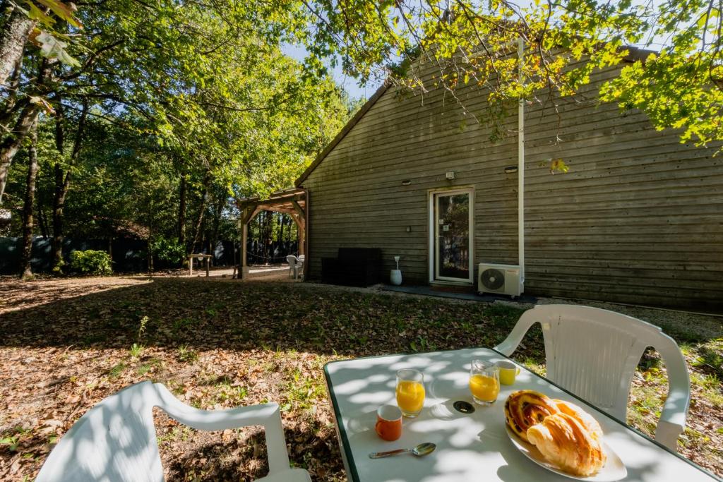 a table with a plate of bread and orange juice on it at Gîte du héron de Sologne Calme classé 3étoiles Forêt WIFI Animaux bienvenus Services ProsConciergerie Comte des Cierges in Brinon-sur-Sauldre