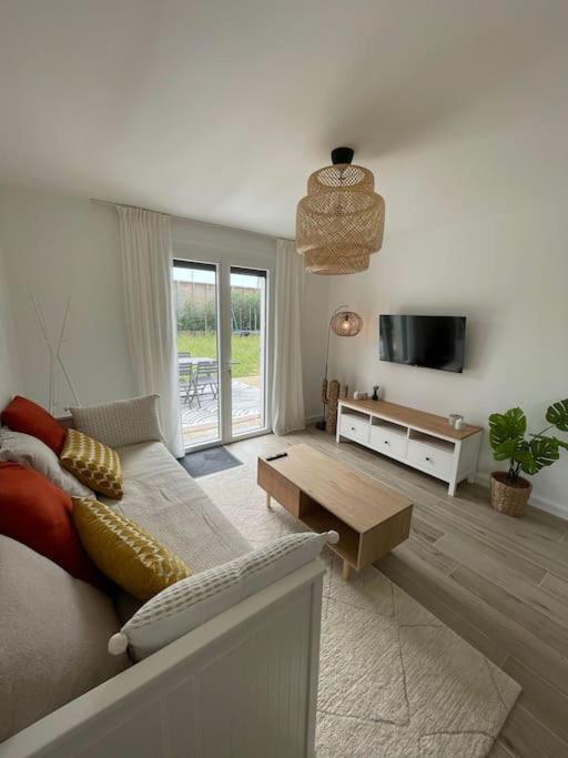 een woonkamer met een bank en een tv bij Appartement proche Stade/Eurexpo in Décines-Charpieu