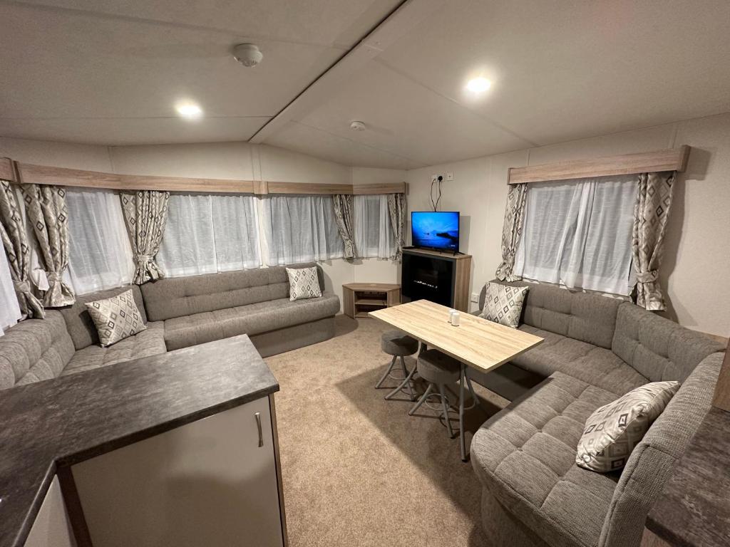 a living room with a couch and a table at Billing Aquadrome Luxury Static Caravan in Great Billing