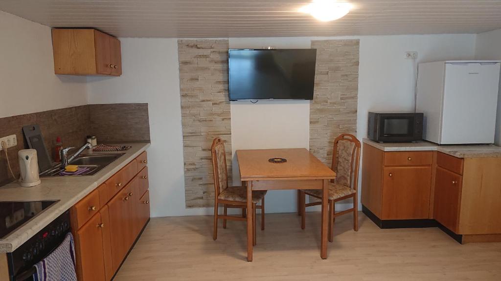 eine kleine Küche mit einem kleinen Tisch und einer Mikrowelle in der Unterkunft Monteur - Ferienwohnung Gönnern für 1 Person in Gönnern