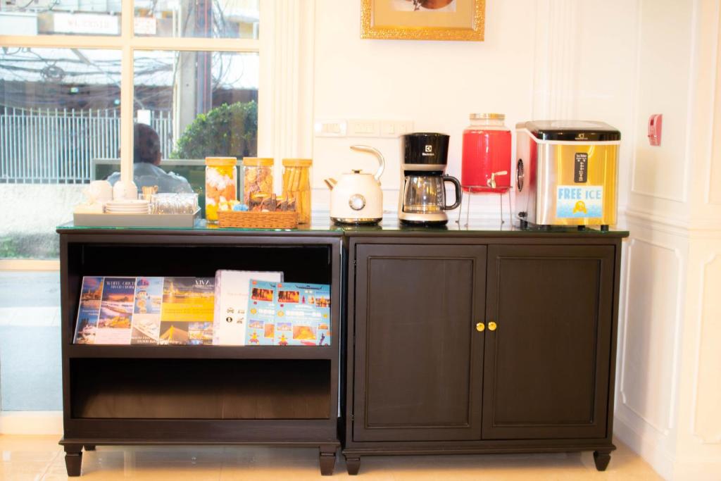 A compact refreshment station with coffee equipment, dispensers and packaged snacks.