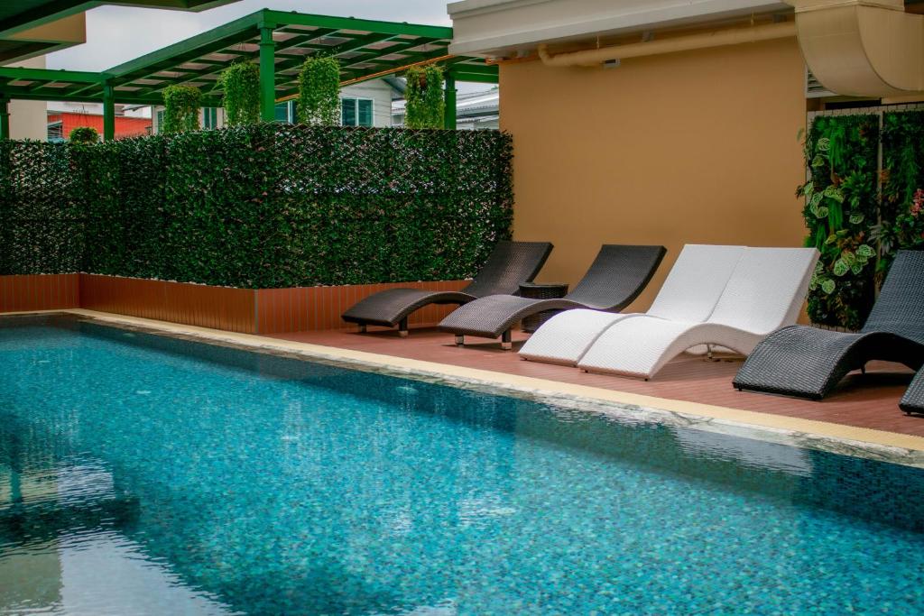 A longer view shows the blue pool bordered by loungers and a screened deck.