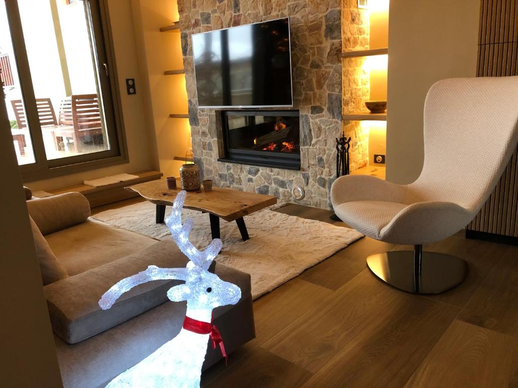 een woonkamer met een hertenbeeld voor een open haard bij Villagio inn Suite & Spa in Soúlion