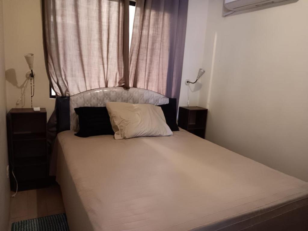 a bedroom with a large white bed with a window at October Homes, One Oasis Ortigas in Manila