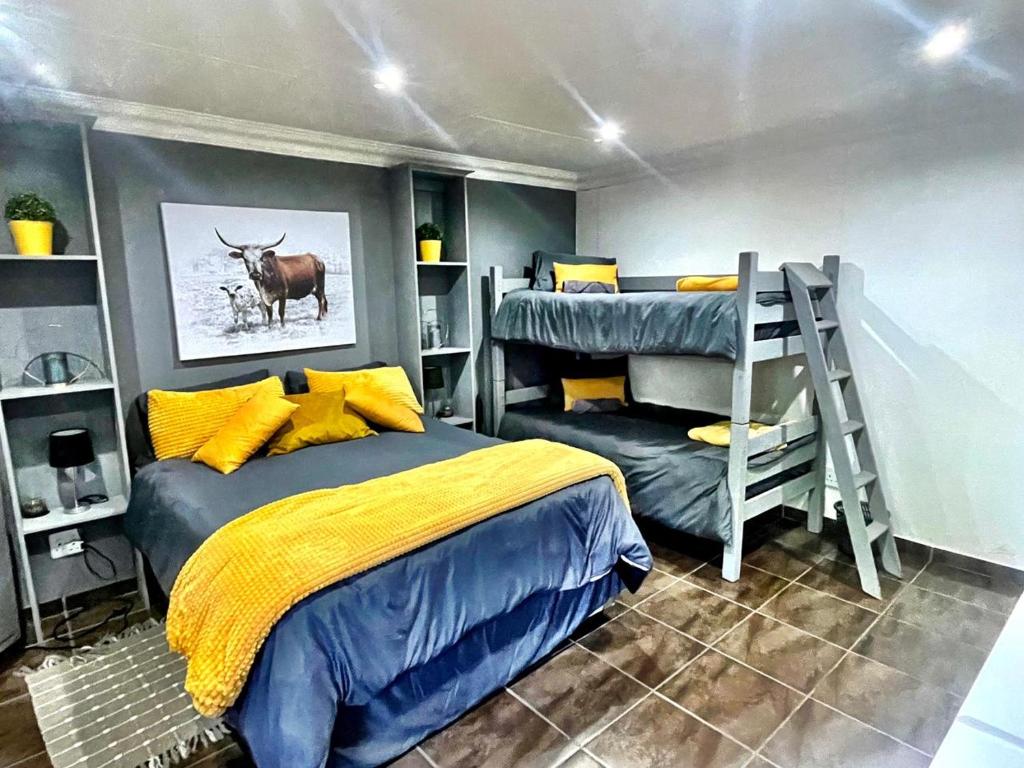 ein Schlafzimmer mit einem Bett, einem Etagenbett und einer Leiter in der Unterkunft Starlight Stay in Groblersdal