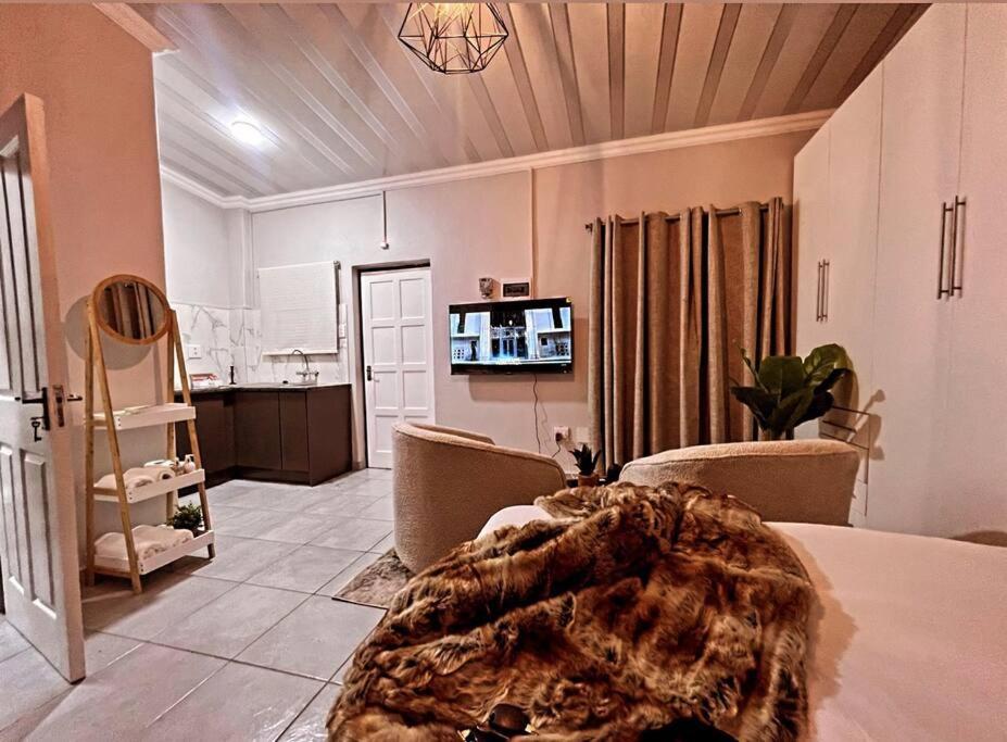 een woonkamer met een bed en een keuken bij La Creme Waterkloof 2 in Pretoria