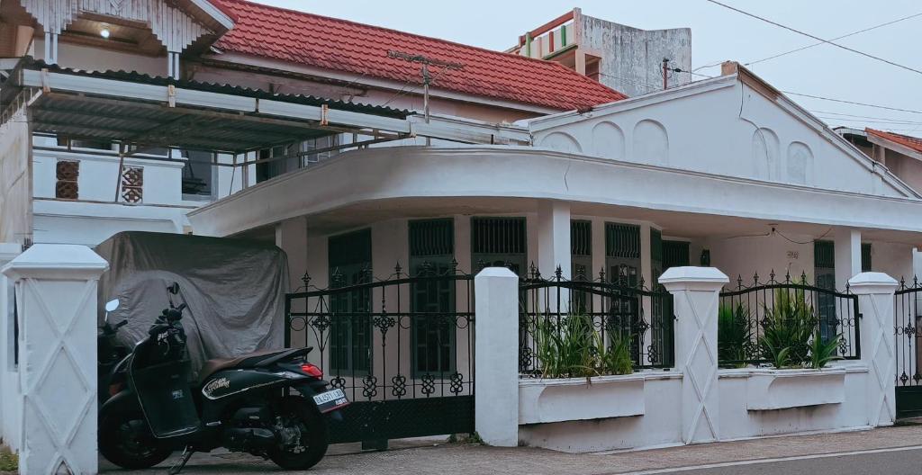 una motocicleta estacionada frente a una casa en Penginapan Terdekat (Near), en Bukittinggi