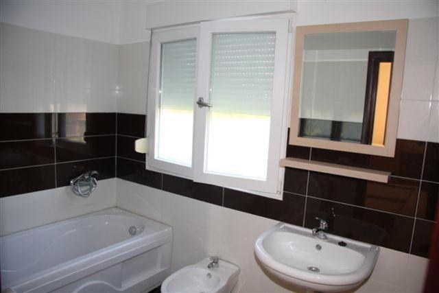 a bathroom with a sink and a toilet and a window at APARTMANI LUX SEA in Utjeha