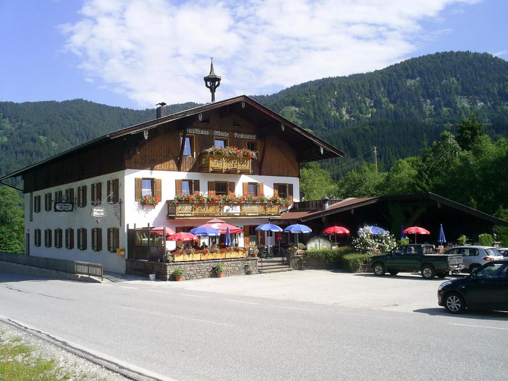 a building with umbrellas on the side of a road at Gasthaus Marie in Achenkirch