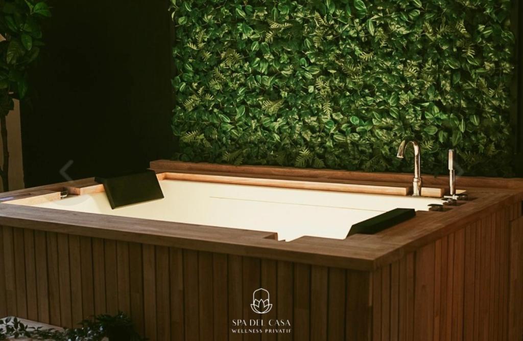 a bath tub in front of a green wall at Spa Niagara privé avec jacuzzi in Herstal