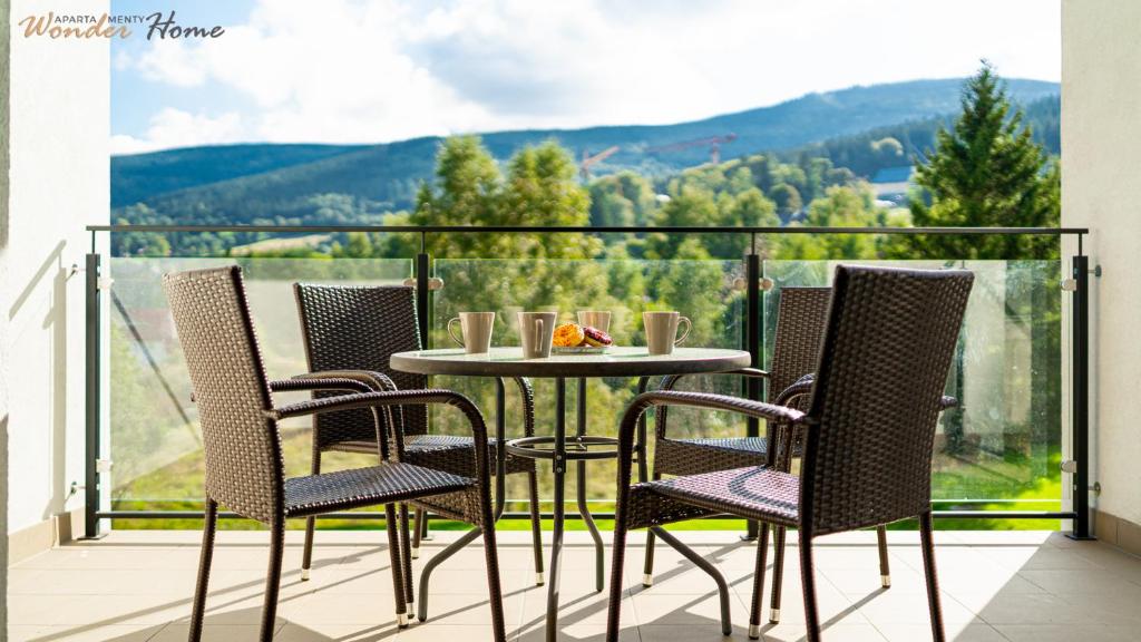 a table and chairs on a balcony with a view at Wonder Home - Apartament Dolce Vita blisko tras rowerowych Single Track i kolei gondolowej in Świeradów-Zdrój