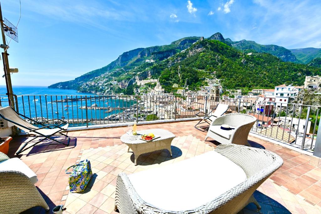 Un balcón con sillas y vistas al océano. en Rooftop flat in Amalfi, en Amalfi