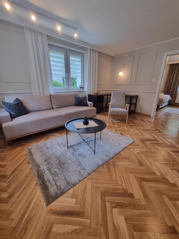 a living room with a couch and a table at Apartamenty 39 z pięknym ogrodem in Ustroń