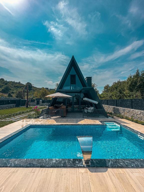 uma piscina com uma casa ao fundo em Sapanca Litha Bungalov em Sapanca