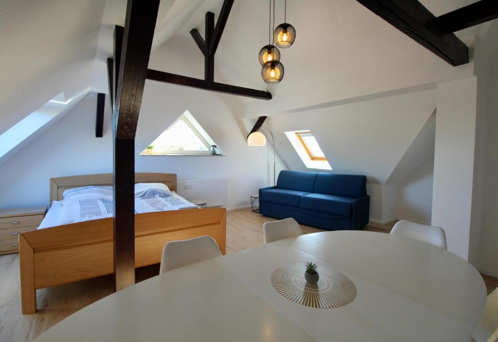 a room with a bed and a white table and chairs at Leipzig Hideaway in Großdeuben