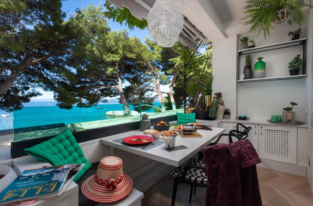 a dining room with a table and a view of the ocean at Beach Apartment 'Hedonist' in Makarska