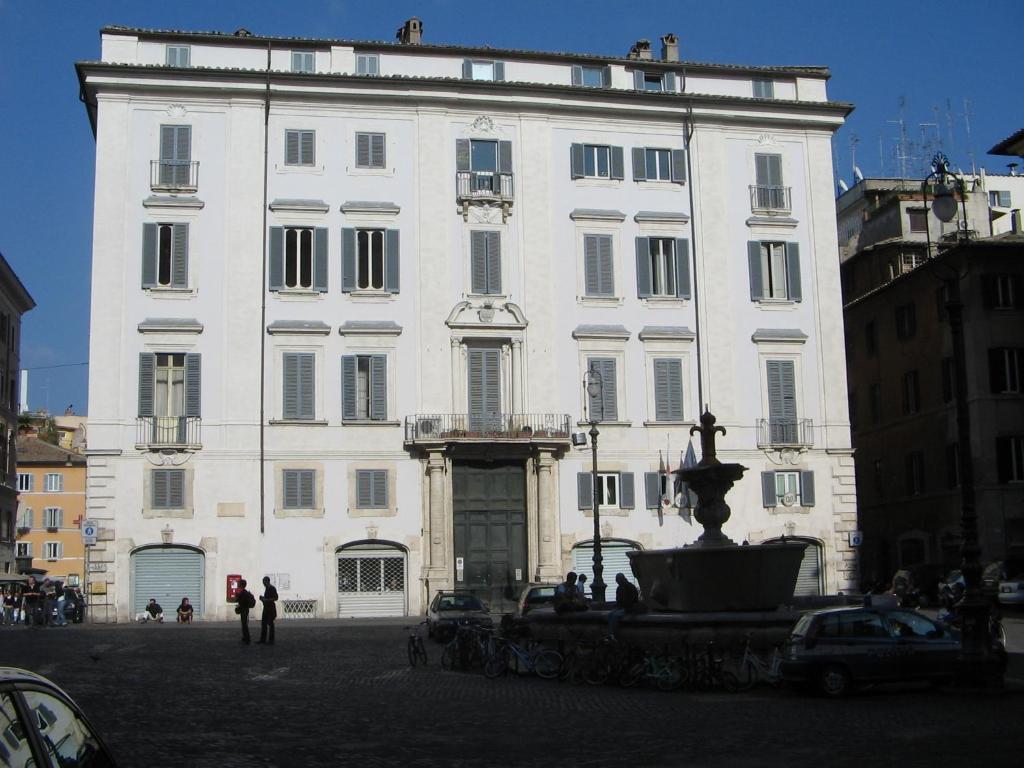 un grand bâtiment blanc avec une fontaine devant lui dans l'établissement Appartamento Piazza Farnese, à Rome