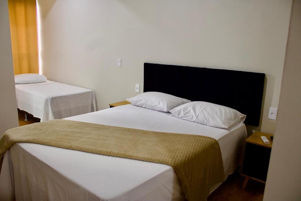 a hotel room with two beds in a room at Pousada Estrela de Davi in Penha
