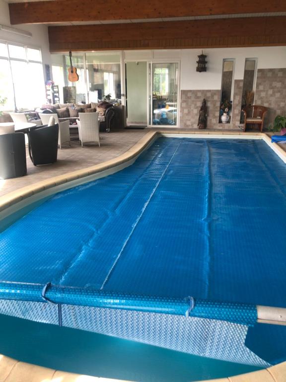 a swimming pool with blue water in a room at Chambre chez l'habitant in Châteauvieux