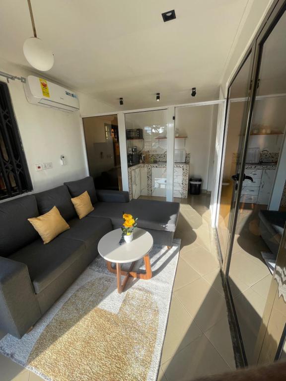 een woonkamer met een bank en een tafel bij Beautiful & Secured yellow House for 2 - Center of Osu in Accra