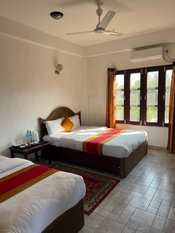 una camera da letto con due letti e una finestra di Chitwan Park Village a Sauraha