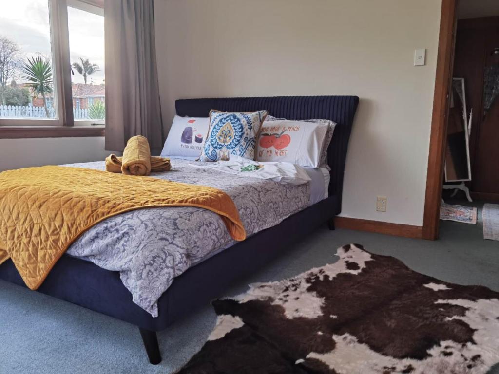 sypialnia z łóżkiem, oknem i dywanem w obiekcie Epsom Red House w Auckland